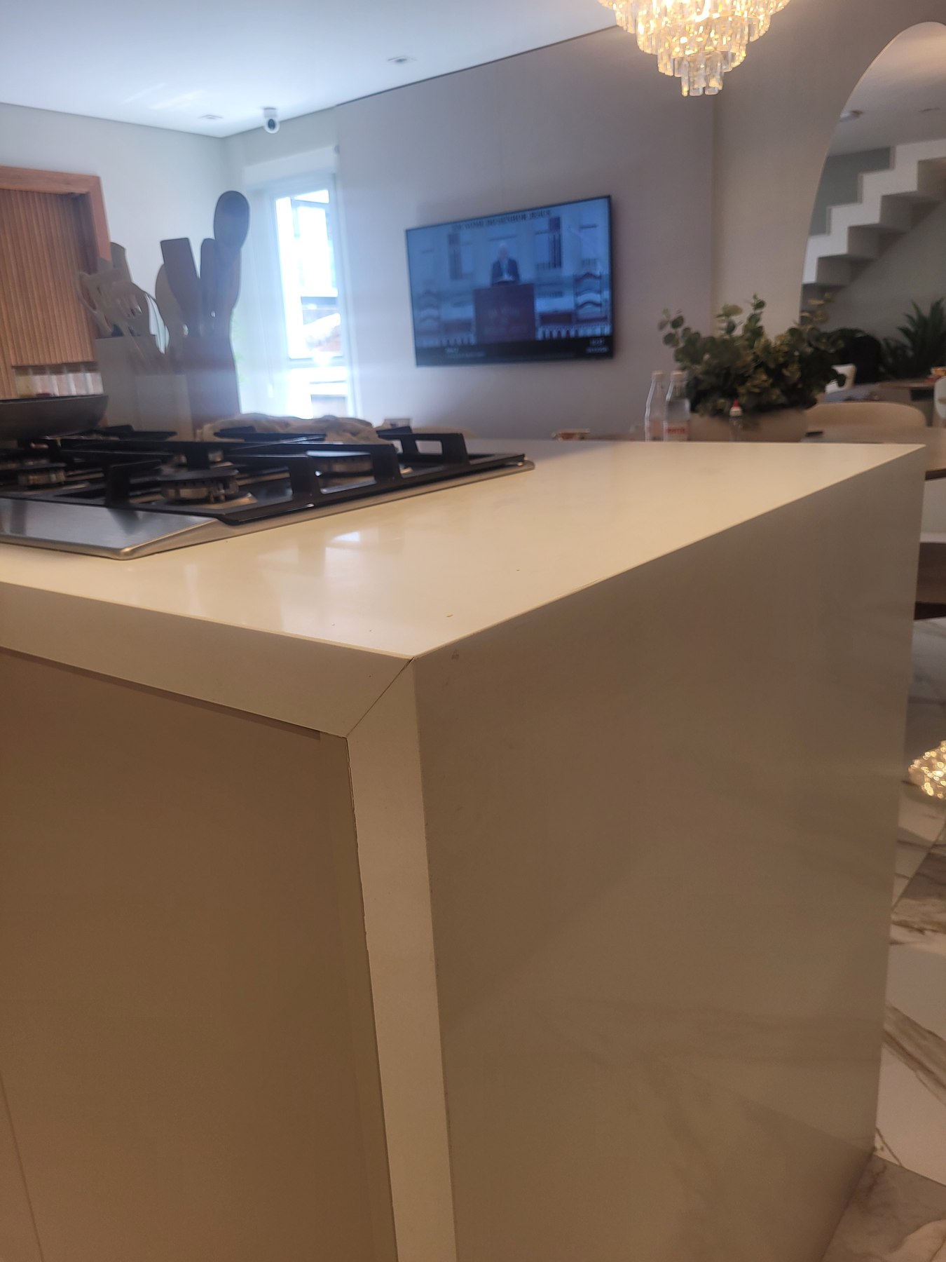 Ilha de cozinha em Quartzo Branco com cooktop embutido e fechamento lateral