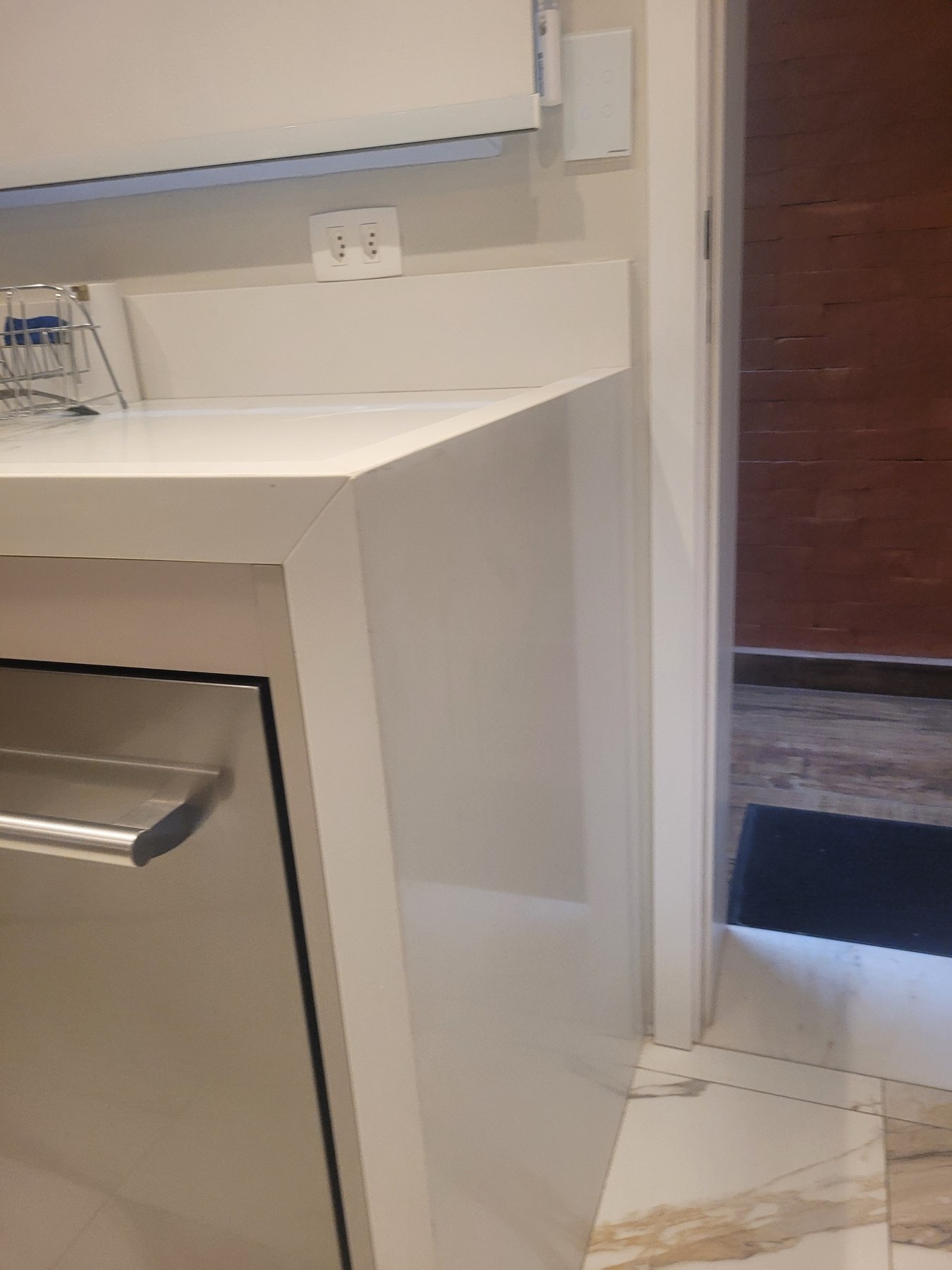 Pia sob medida em Quartzo Branco com frontão e fechamento lateral junto à cozinha