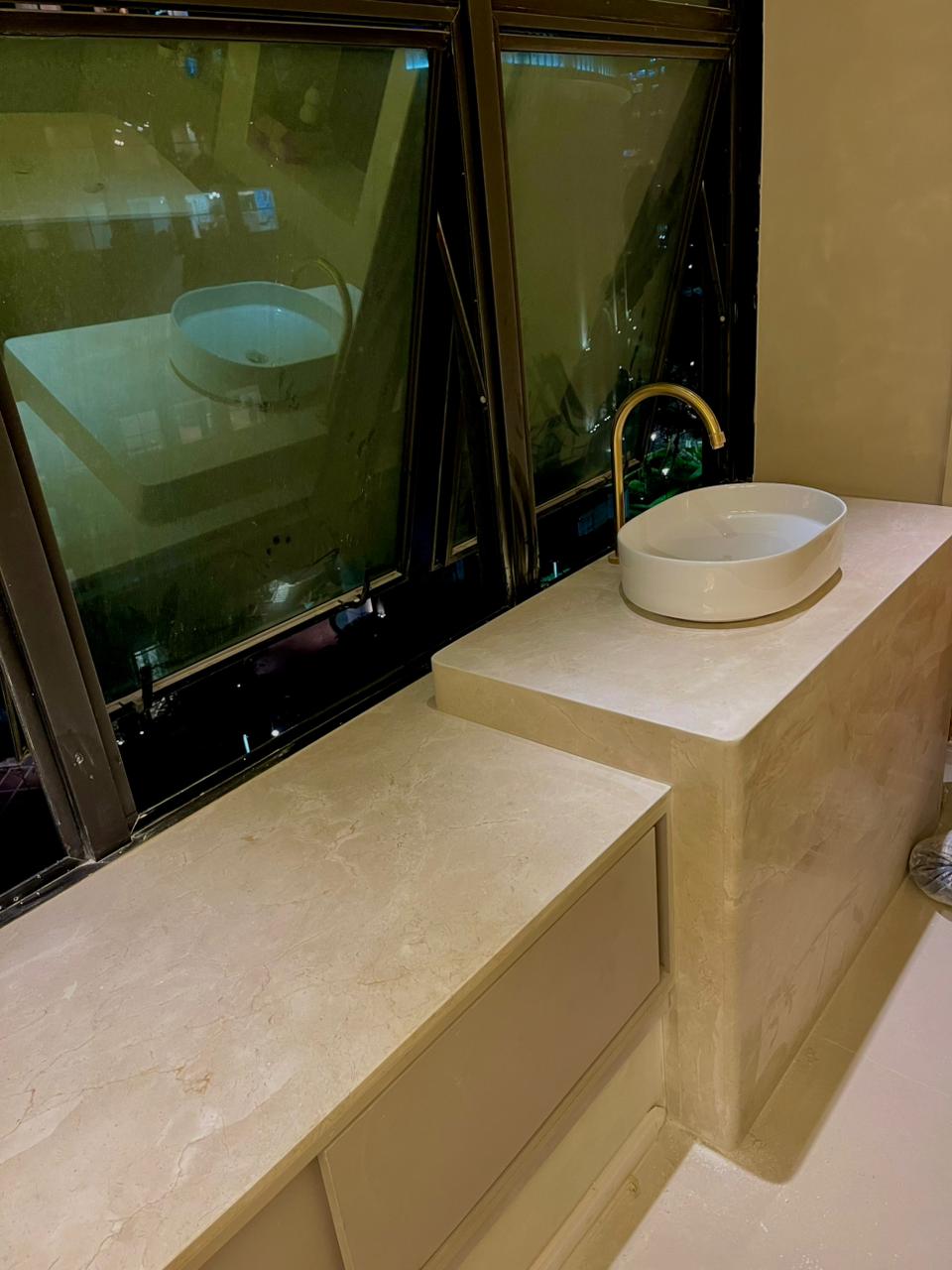 Lavabo com bancada em mármore bege em dois níveis e cuba de apoio branca